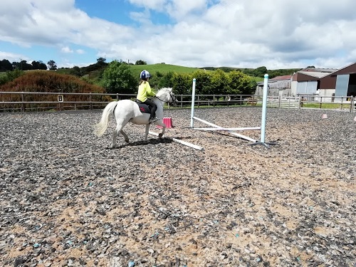 Child jumping tiny pony